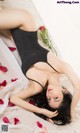 A woman laying on a bed covered in rose petals.