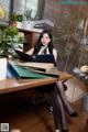 A woman sitting at a desk with a laptop computer.