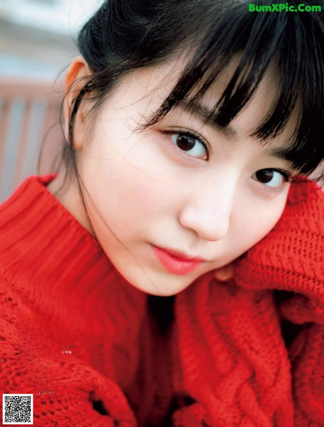 A woman in a red sweater is posing for a magazine.