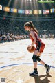 A woman in a red and black uniform holding a basketball on a court.