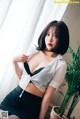A woman in a white shirt and black skirt posing for a picture.