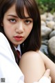 A woman in a white shirt and red tie posing for a picture.