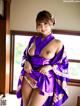 A woman in a purple kimono posing for the camera.