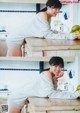 A woman sitting at a kitchen counter with a bowl of fruit.