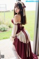 A woman in a maroon and white dress posing for a picture.