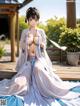 A woman in a white kimono sitting on a wooden deck.